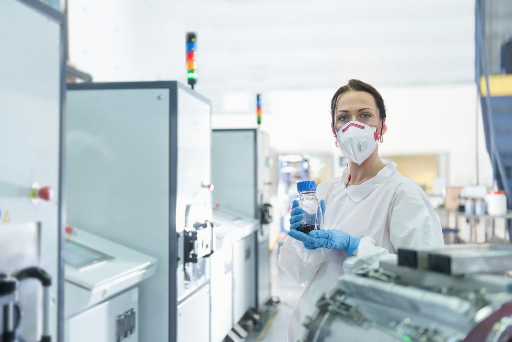 Portrait of female scientist holding graphene nano-platelets sample in graphene processing factory